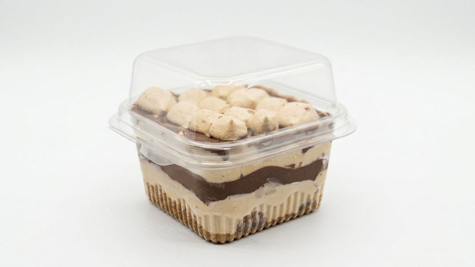 Imagem de uma sobremesa de gelato de chocolate e baunilha em embalagem plástica com cobertura de pedacinhos de biscoito, ideal para artigos sobre sobremesas e alimentação.