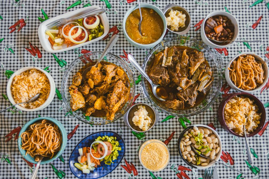 Mesa com uma variedade de comidas tradicionais e acompanhamentos para uma refeição caseira ou de celebração, destacando a diversidade e sabor da culinária brasileira.