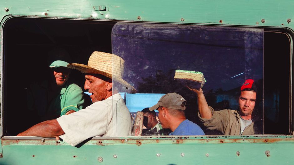Grupo de homens em um veículo antigo, ilustrando um momento de convivência e trabalho informal em ambiente rural.