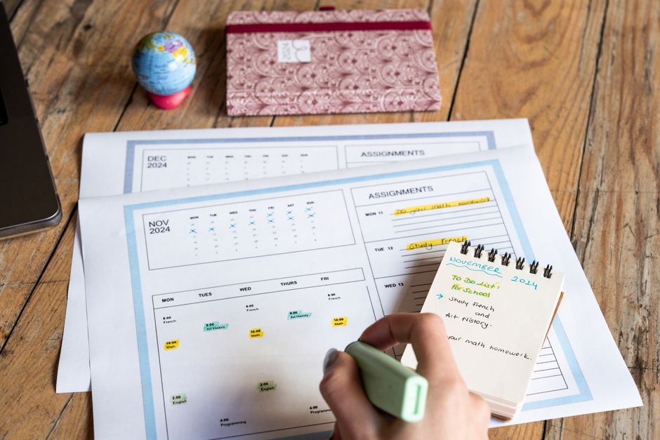 Imagem de uma mesa de estudos com planejamento acadêmico, incluindo calendário, caderno de anotações e materiais de estudo, ideal para artigos sobre organização e gestão de estudos.
