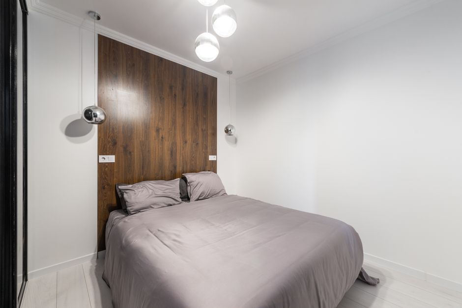 Quarto moderno com cama elegante e iluminação discreta, ideal para ambientes de descanso e design de interiores.