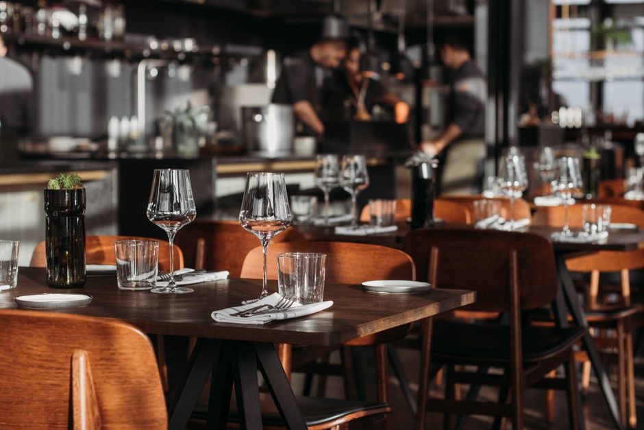 Imagem de um restaurante sofisticado com mesas bem decoradas e ambiente elegante, pronto para receber clientes.