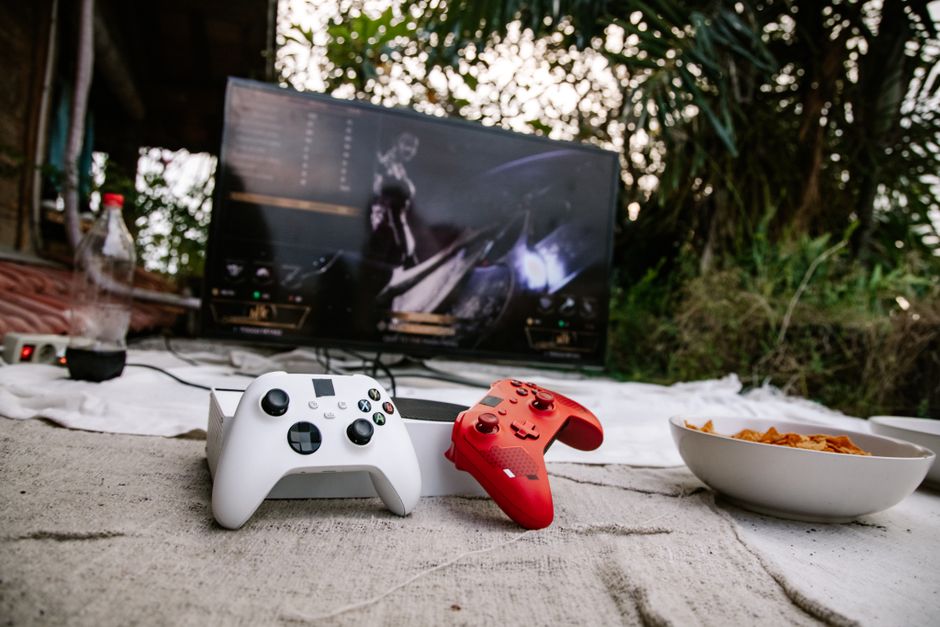 Configuração de um espaço ao ar livre dedicado ao entretenimento com videogames e petiscos, ideal para momentos de lazer em ambiente natural.