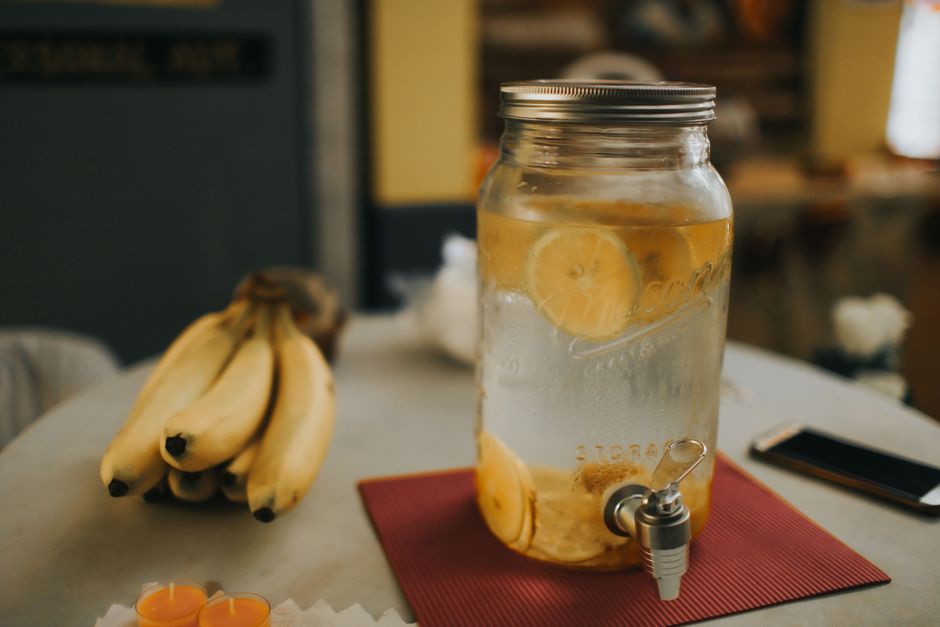 Jarra de água com fatias de limão na mesa de uma cozinha ou sala de convivência, transmitindo uma sensação de refrescância e tranquilidade.