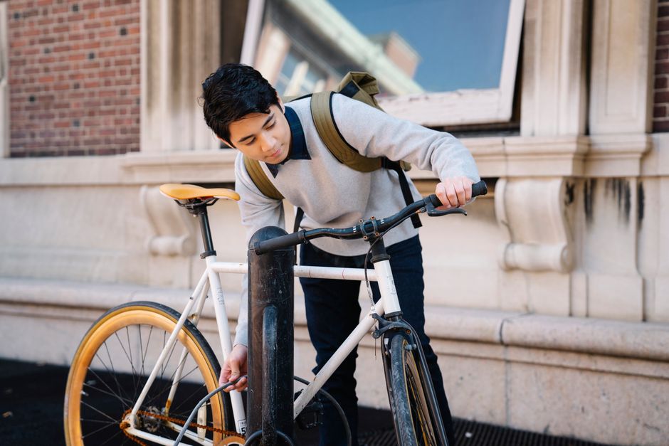 Jovem ajustando sua bicicleta em um ambiente urbano, simbolizando saúde, mobilidade e sustentabilidade.