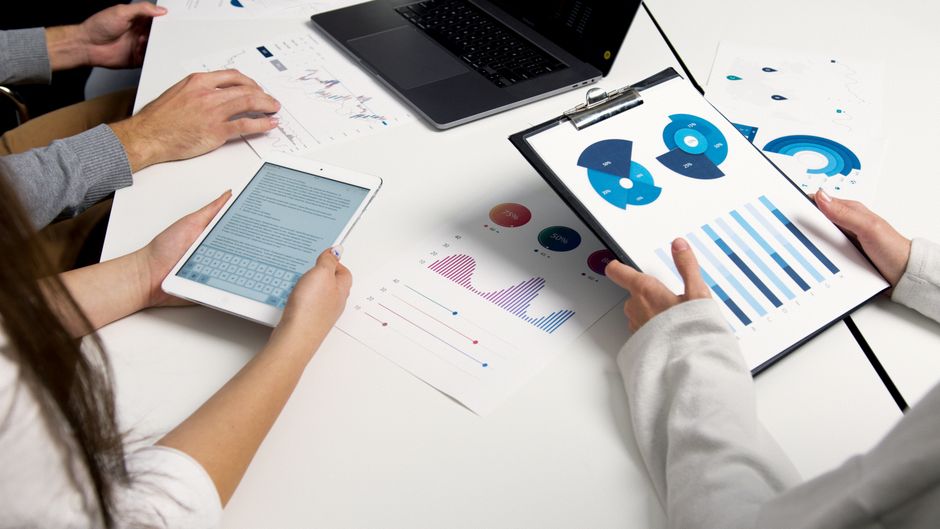 Reunião de equipe analisando dados e relatórios financeiros para tomada de decisões estratégicas.