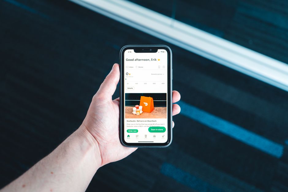 Pessoa usando um smartphone para fazer pedidos via delivery, destacando a conveniência do comércio digital.