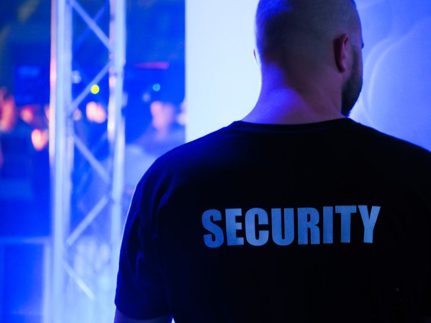 Homem de segurança monitorando ambiente em evento com iluminação azul