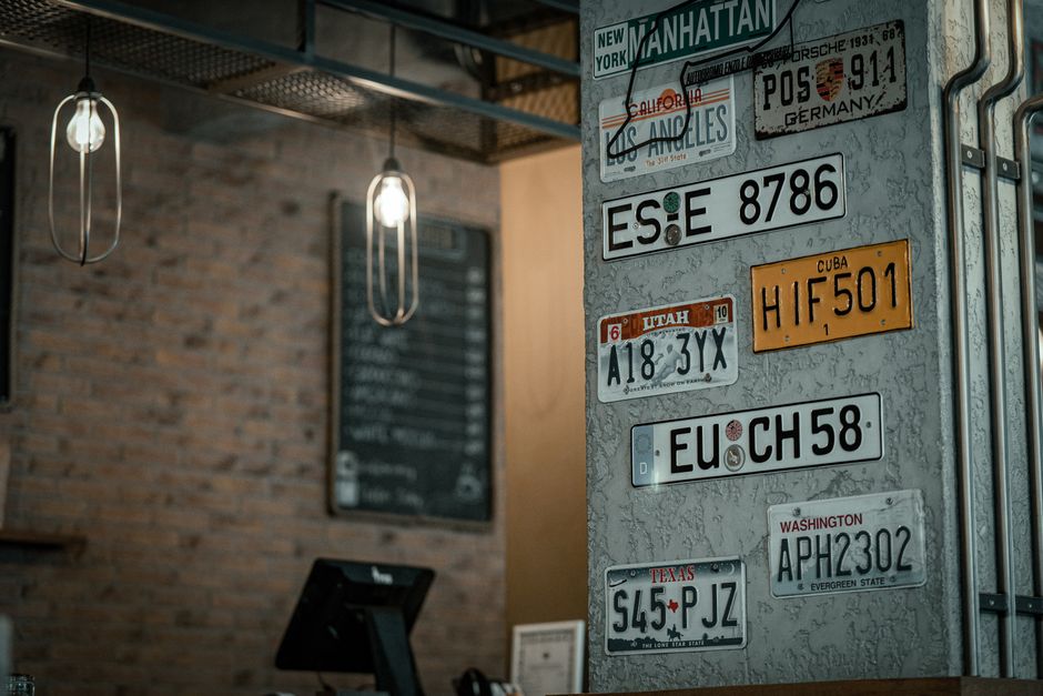 Imagem de um ambiente com decoração industrial, destacando uma parede com placas de diferentes países que evocam o tema de viagens e diversificação.