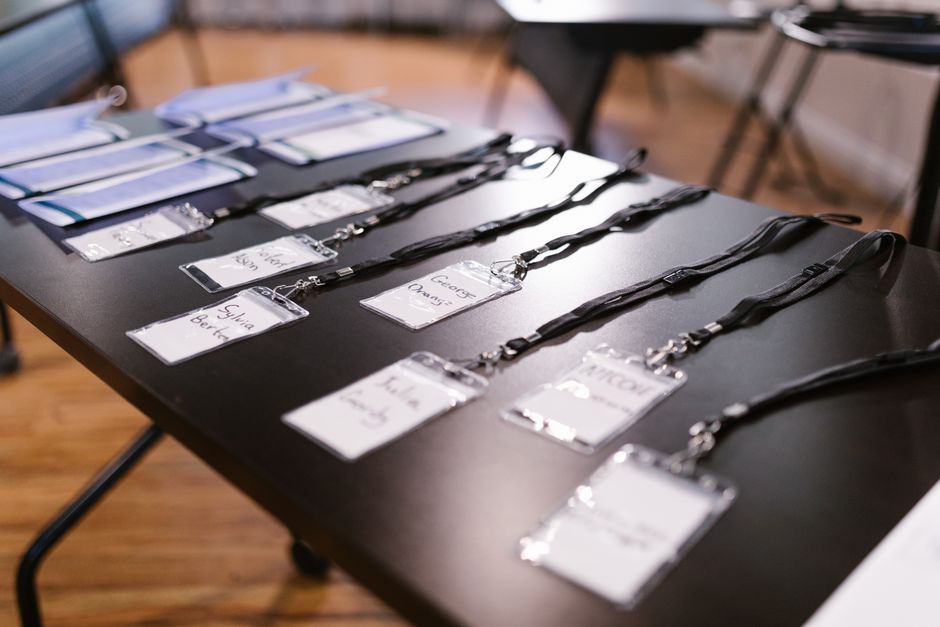 Mesa com crachás de identificação organizados, prontos para evento corporativo ou conferência, com foco na gestão de eventos e networking profissional.
