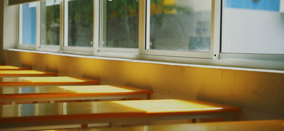 Salas de aula vazias com janelas iluminadas pelo sol, transmitindo sensação de tranquilidade e expectativa de aulas futuras.