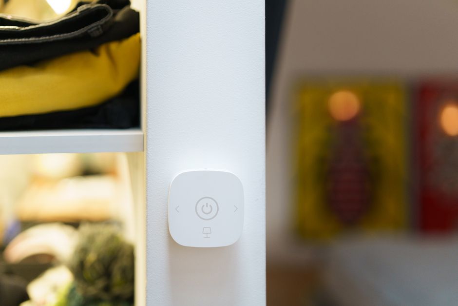 Dispositivo inteligente de controle de iluminação instalado na parede de um interior residencial ou comercial.