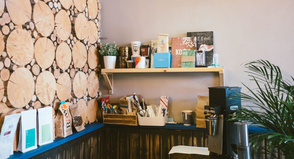 Espaço de uma cafeteria com balcão de atendimento, máquinas de café e itens relacionados ao preparo de bebidas, criado para destacar o ambiente de consumo de café.