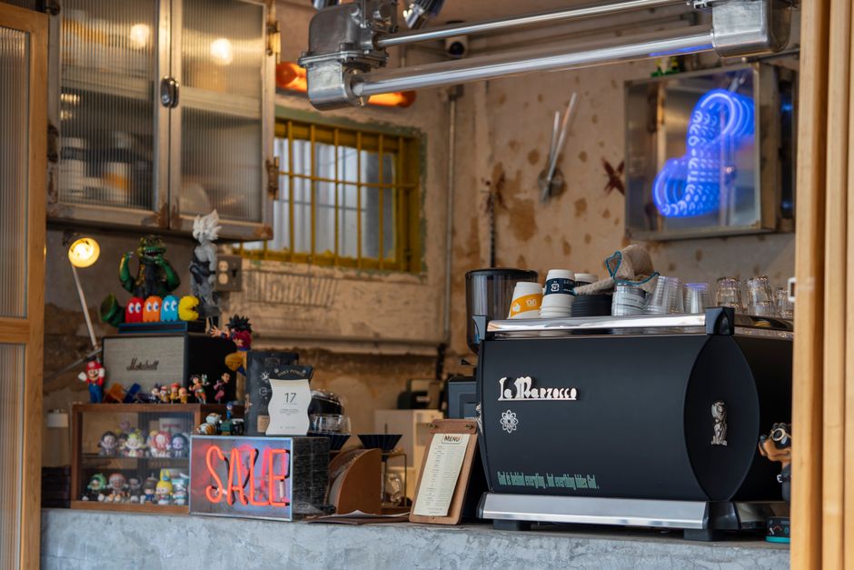 Ambiente de cafeteria com elementos de decoração e equipamentos utilizados na preparação de bebidas, transmitindo um clima acolhedor e descontraído.