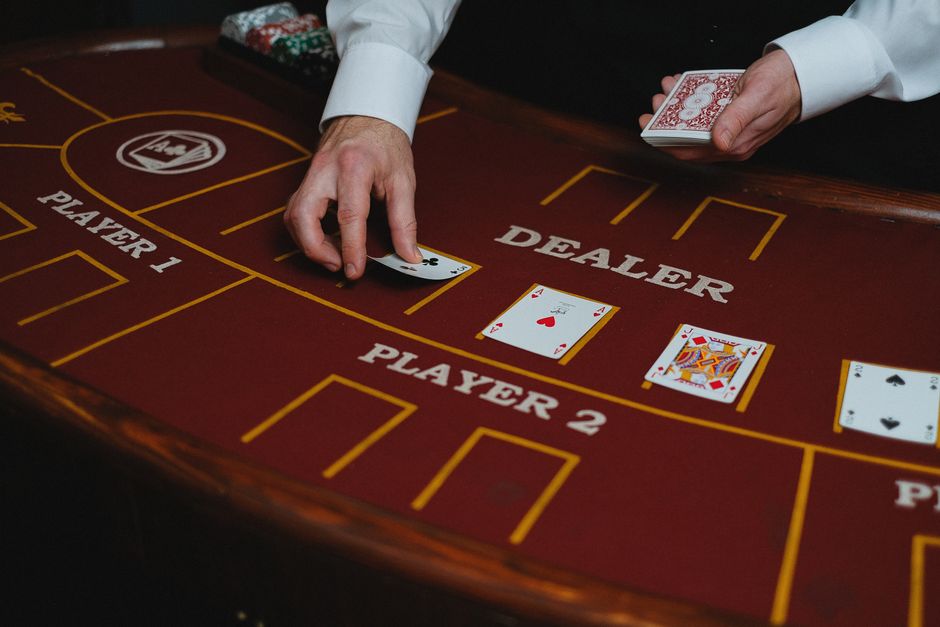 Imagem de uma mesa de blackjack em um cassino, com um dealer lidando as cartas aos jogadores, destacando a atmosfera de jogos de azar.