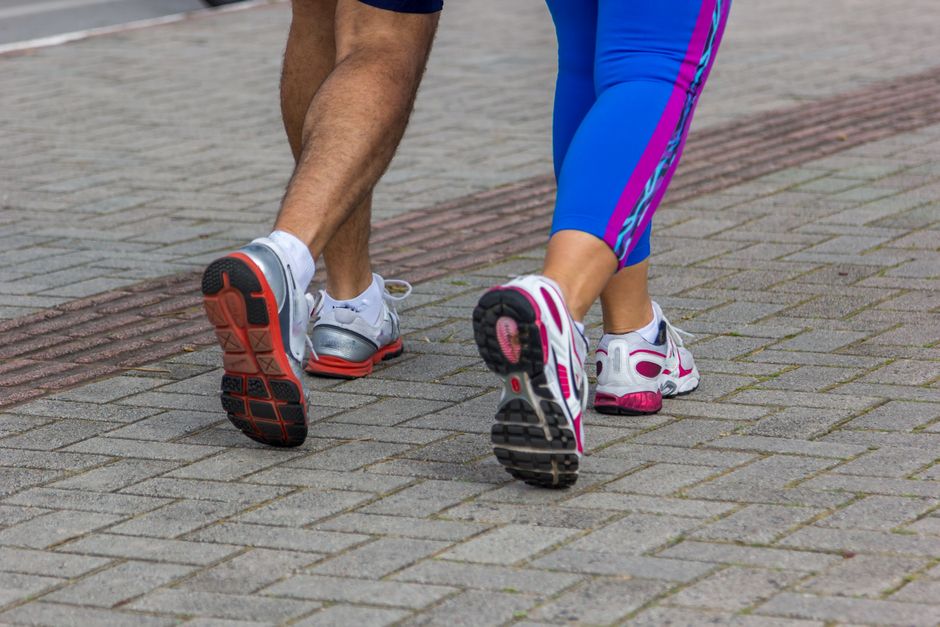 Pessoas caminhando ao ar livre, destacando a prática de exercícios físicos ao ar livre.