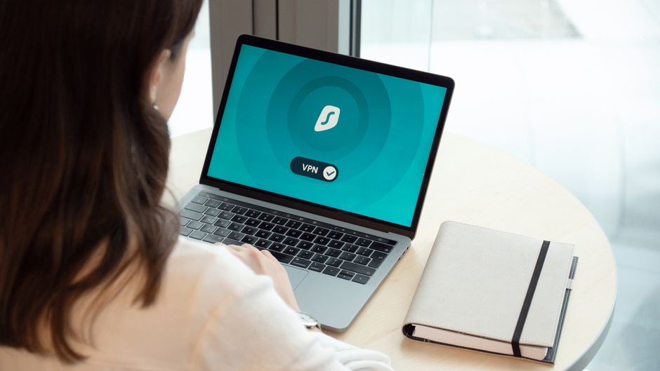 Pessoa conectada à internet usando VPN em ambiente de trabalho, simbolizando segurança digital e privacidade online.