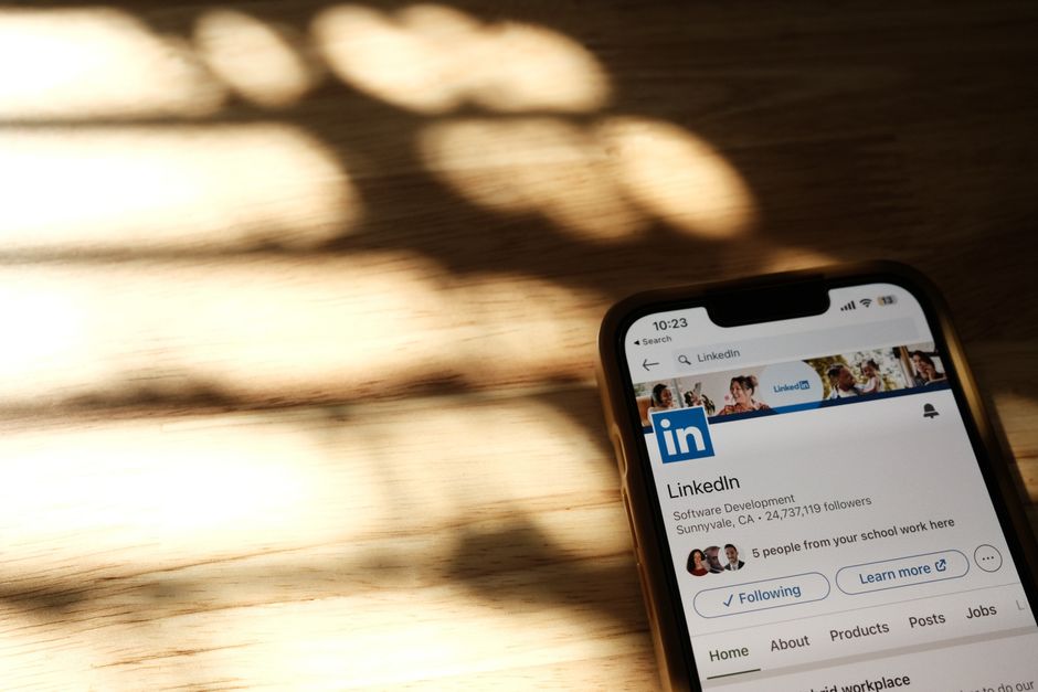 Imagem de um smartphone exibindo o perfil do LinkedIn, representando networking profissional e marketing digital.