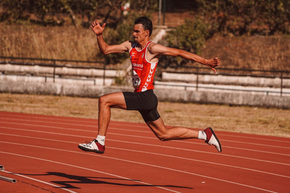 Atleta de velocidade em ação durante uma corrida em pista de atletismo ao ar livre