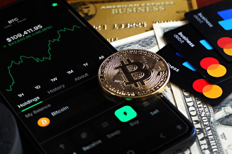 Imagem ilustrando investimentos em criptomoedas e finanças digitais, com foco em bitcoin e moedas de papel, representando o tema de finanças e mercado financeiro moderno.