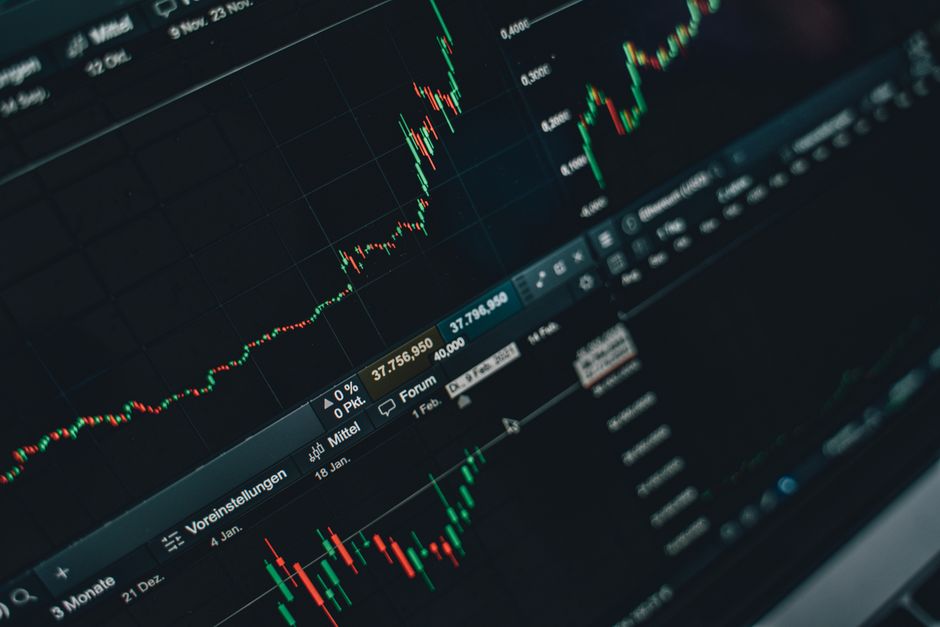 Imagem de um gráfico de análise de mercado financeiro, representando tendências de alta e baixa de ativos.