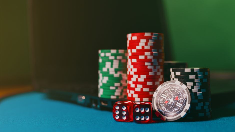 Imagem de fichas de poker, dado e um chip representando apostas ou jogos de azar em um ambiente de casino ou casa de apostas.