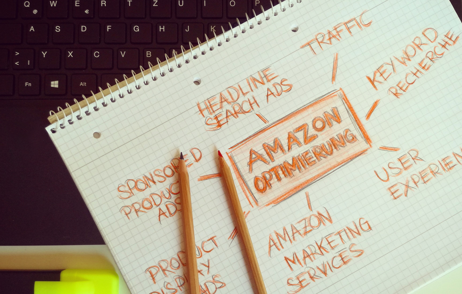 Anotações de estratégias de otimização de Amazon em um caderno de grid, com lápis, sobre marketing digital e vendas online.