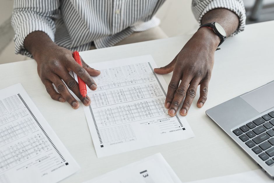 Pessoa analisando planilhas financeiras enquanto trabalha no computador, destacando o tema de gestão financeira e planejamento empresarial.