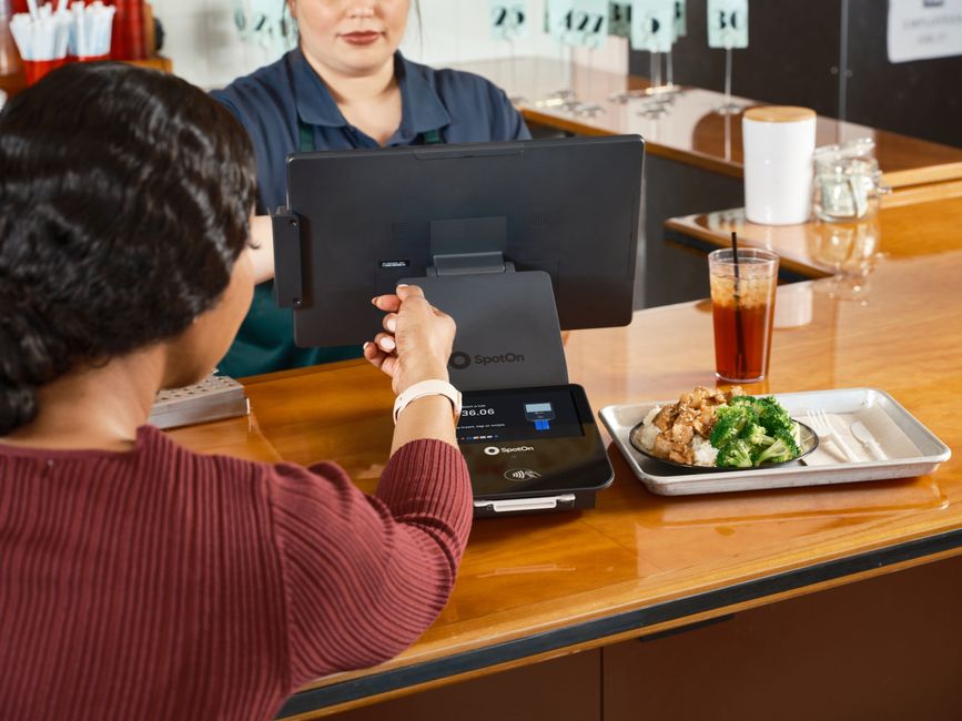 Pessoa realizando pagamento com cartão de crédito em um estabelecimento de alimentação, destacando o tema de gestão financeira e pontos de venda.