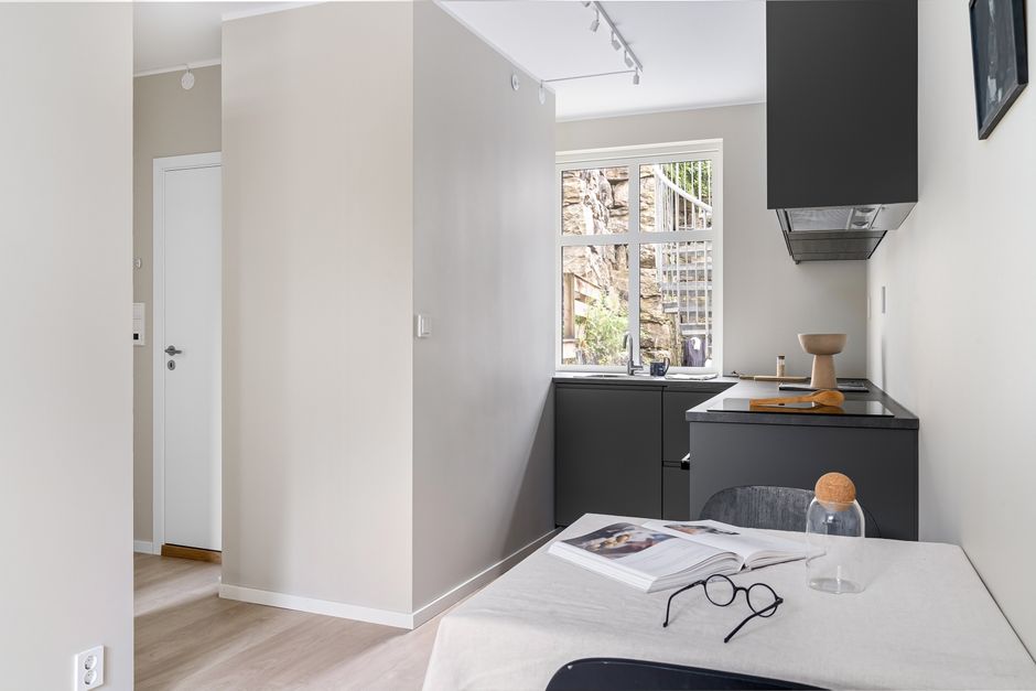 Interior de cozinha moderna com design minimalista, iluminação natural e detalhes de decoração simples.