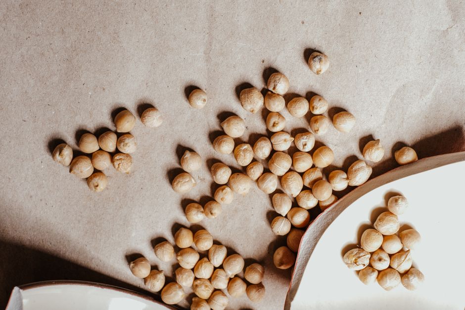 Imagem de grão de soja espalhado sobre uma superfície, simbolizando agricultura ou alimentação saudável.