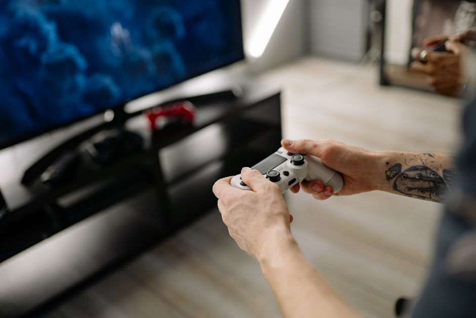 Pessoa jogando videogame em ambiente de lazer, evidenciando o ato de jogar e diversão.