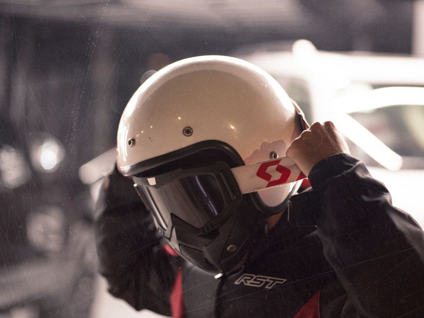 Pessoa ajustando o capacete de proteção antes de realizar uma atividade de esporte motorizado.