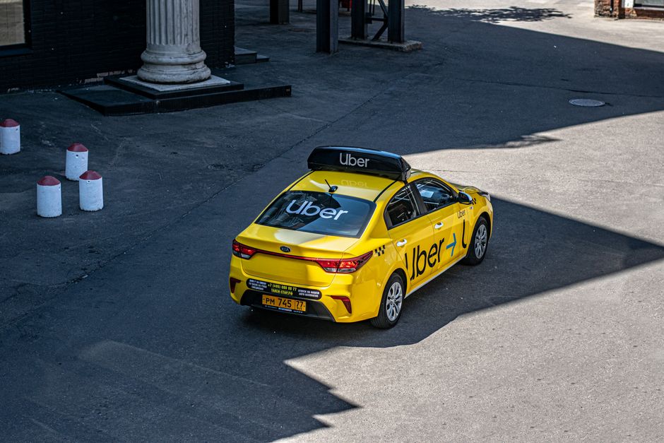 Carro de aplicativo Uber estacionado em área urbana, destacando o serviço de transporte por aplicativo.