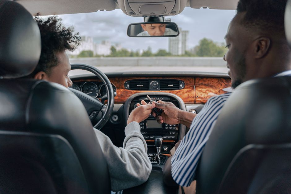 Um casal trocando alianças dentro de um carro, simbolizando compromisso e união.