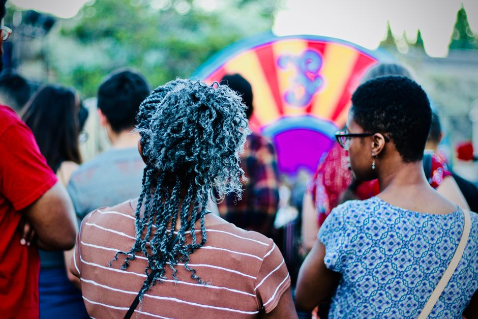 Pessoas participando de um evento ao ar livre com foco na diversidade e inclusão social.