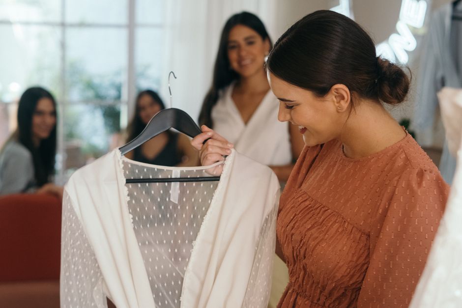 Mulher feliz escolhendo uma roupa na loja, destacando o tema de moda e compras