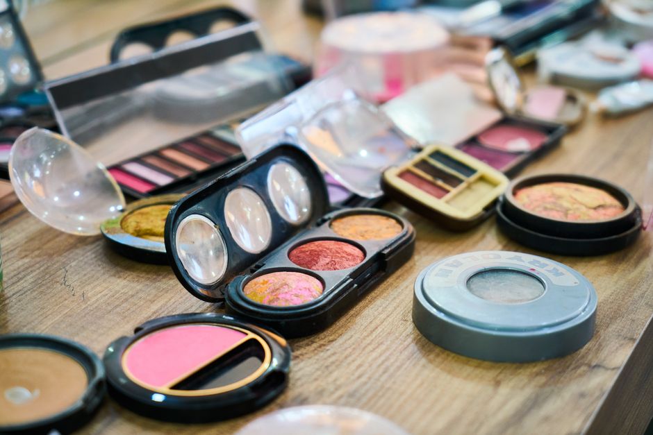 Imagem de uma mesa com diversos produtos de maquiagem e cosméticos usados para beleza e cuidados pessoais.