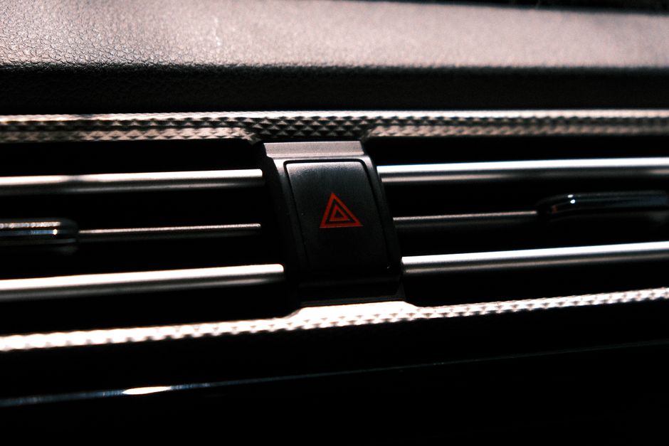 Imagem de um painel de ar-condicionado de carro em foco, com ênfase na ventilação e sistema de controle do veículo.