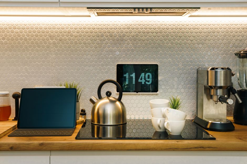Cozinha moderna com detalhes minimalistas e eletrodomésticos de inox, ideal para artigos sobre organização e design de ambientes residenciais.