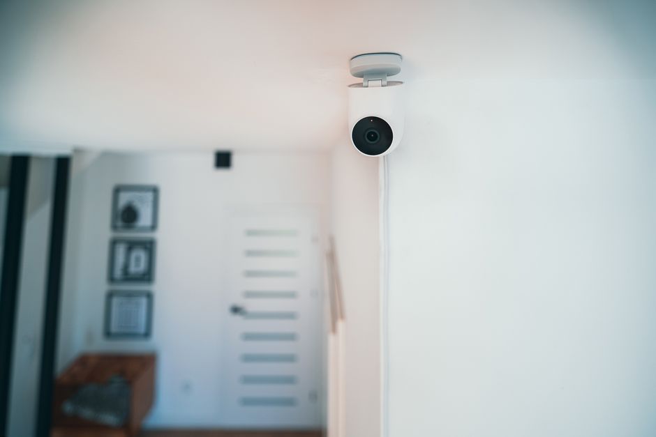 Câmera de segurança instalada na parede de um ambiente moderno, evidenciando tecnologias de monitoramento e segurança.