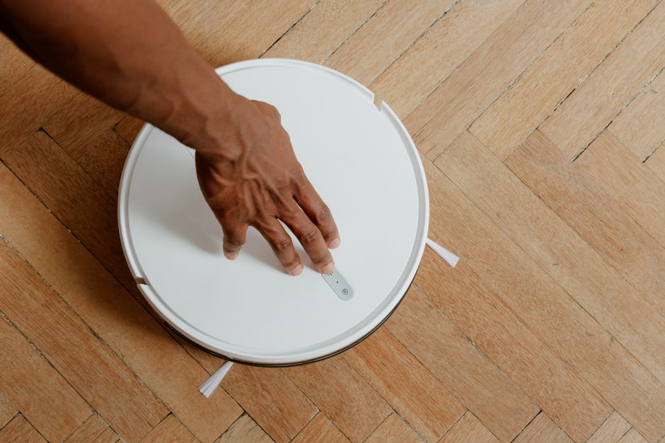 Imagem de um robô aspirador de pó em ação, ilustrando tecnologia de automação residencial.