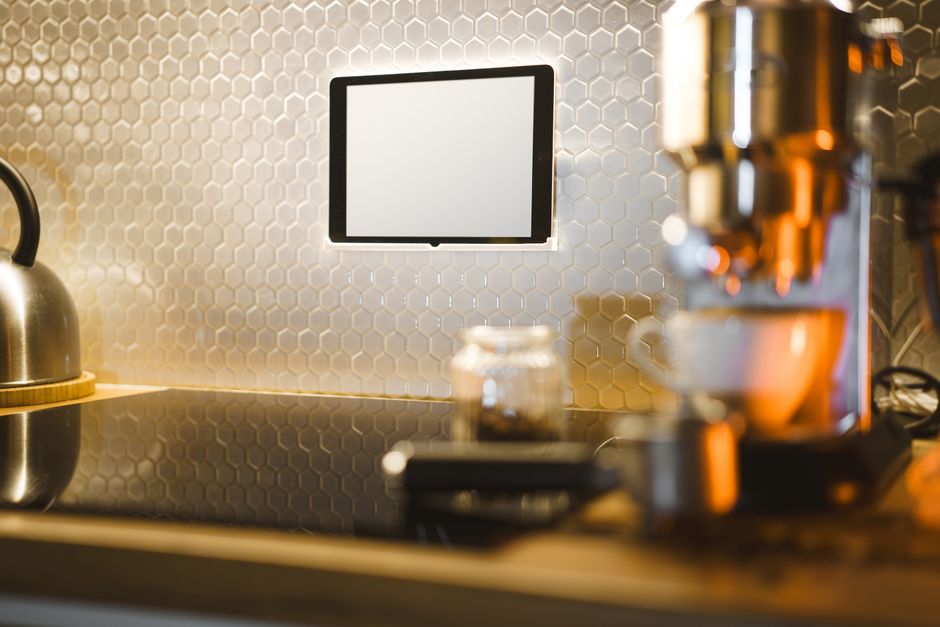 Imagem de uma cozinha moderna com destaque para uma parede com revestimento hexagonal, um micro-ondas e uma chaleira, criando um ambiente contemporâneo e funcional.