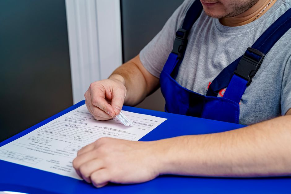 Homem preenchendo um formulário de forma cuidadosa, destacando a importância do atendimento ao cliente ou processos administrativos.