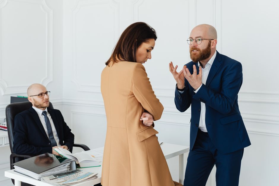 Conversa acalorada entre colegas de escritório em um ambiente de trabalho corporativo, destacando conflitos e expressões faciais.