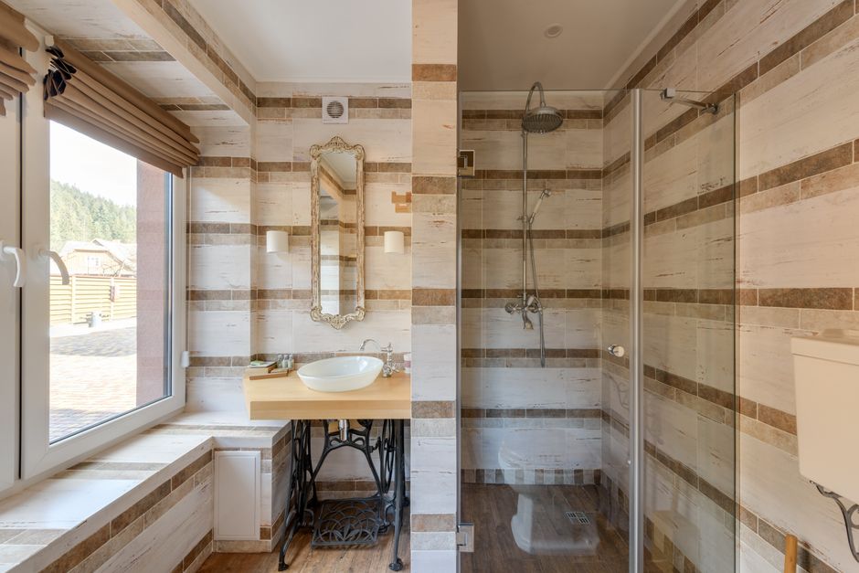 Imagem de um banheiro moderno com decoração de estilo rústico, banheiro com banheira ao lado de um chuveiro e uma pia com espelho, ideal para blog de decoração ou reforma de interiores.