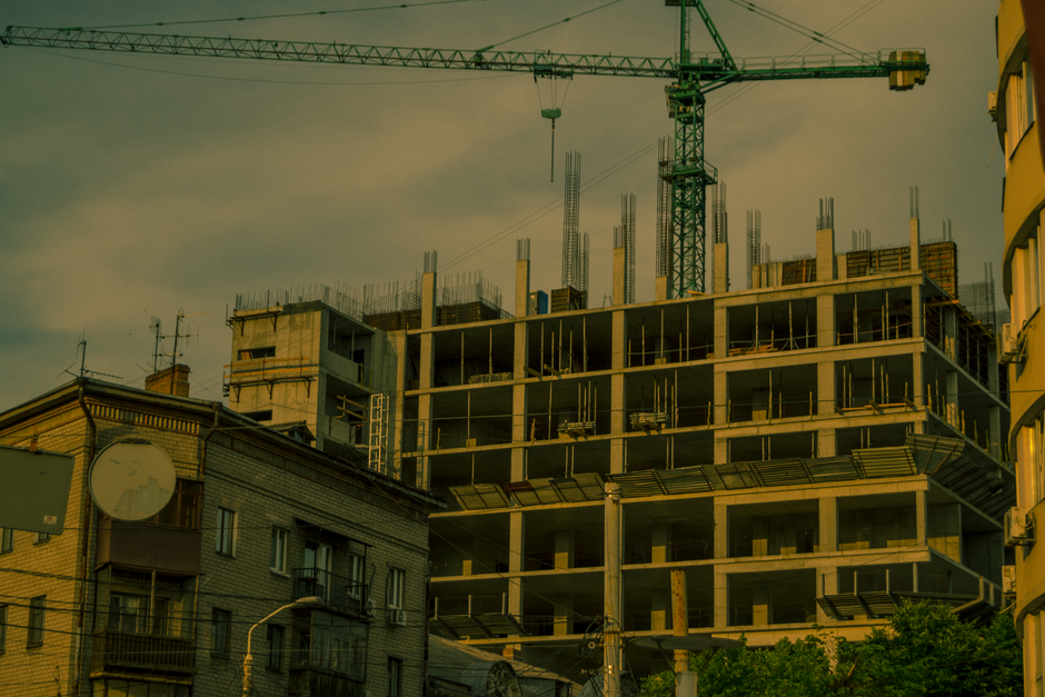 Imagem de um prédio em construção com guindaste, ilustrando o desenvolvimento urbano e obras civis.