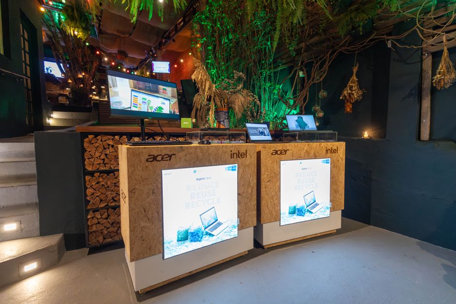 Estação de tecnologia ecológica com displays digitais e ambiente decorado com elementos naturais para um blog sobre sustentabilidade e inovação em negócios.