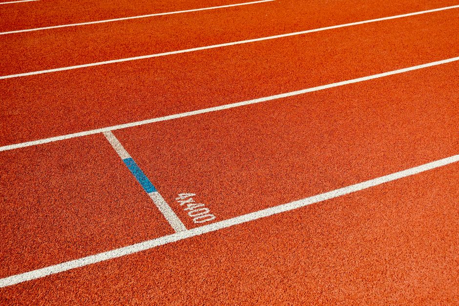 A imagem mostra a linha de chegada de uma pista de corrida, simbolizando conquista e metas atingidas.