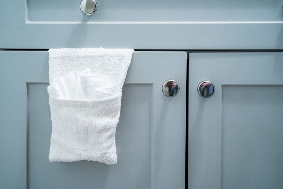 Ganchos em uma porta de armário com um pano de limpeza, sugerindo manutenção ou organização do ambiente.